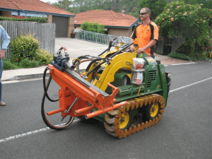 Team member operating a Kanga drill rig on a residential street.