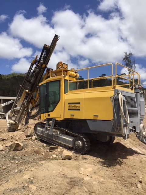 A yellow Atlas Copco Drill Rig drilling for the construction of bored piers to create reinforced concrete foundations for heavy loads.