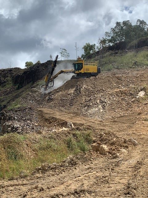 Beards drilling rig positioned on the edge of a quarry bund during drill and blast operations.