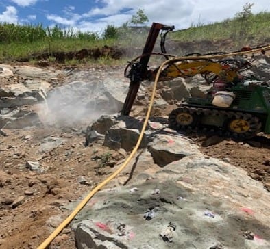 A Kanga Drill bores into tough rock to place expanding grout. A non-explosive method of breaking apart hard rock.