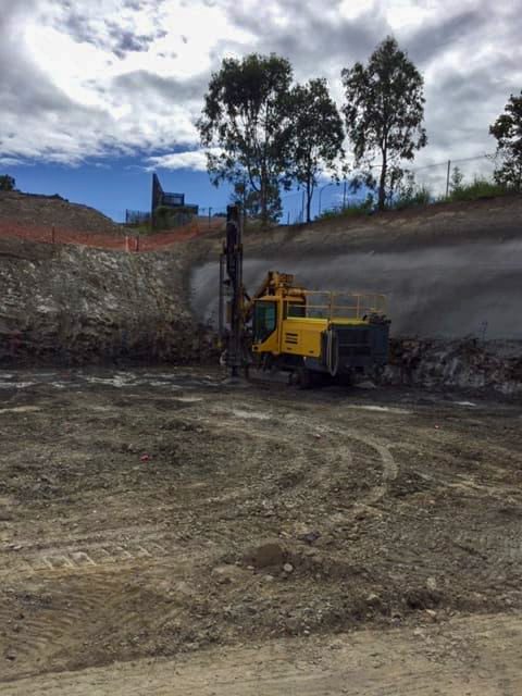 Drilling down into the earth on a levelled pad for the installation of bore piers to reinforce the foundation;